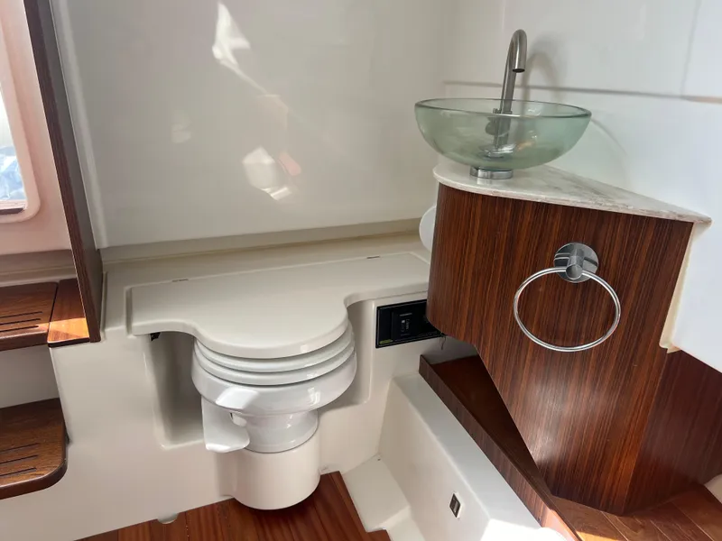 Slide: The Image of 2024 Pursuit S 328 Sport boat bathroom with modern sink and wooden accents. - 20