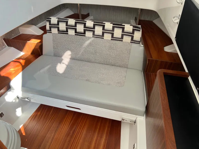 Slide: The Image of 2024 Pursuit S 328 Sport interior with cushioned seating and wooden flooring. - 21