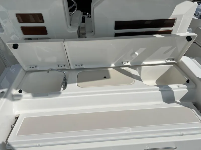 Slide: The Image of 2024 Pursuit S 328 Sport boat interior with sink and storage compartments. - 26
