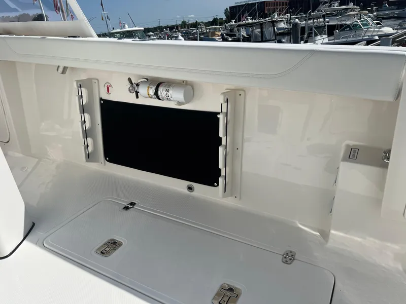 Slide: The Image of 2024 Pursuit S 328 Sport boat interior with storage compartment and fire extinguisher. - 28