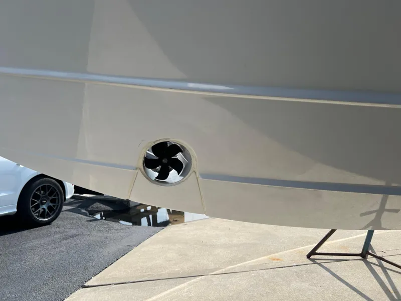 Slide: The Image of 2024 Pursuit S 328 Sport boat hull with visible thruster, parked on a stand. - 5