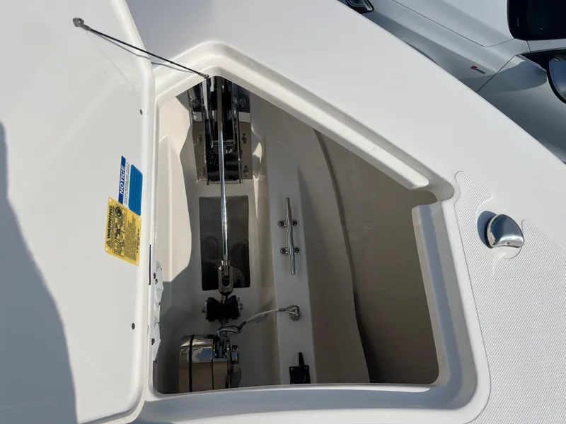 Slide: The Image of 2024 Pursuit S 328 Sport boat anchor compartment, open lid, showcasing interior details. - 9