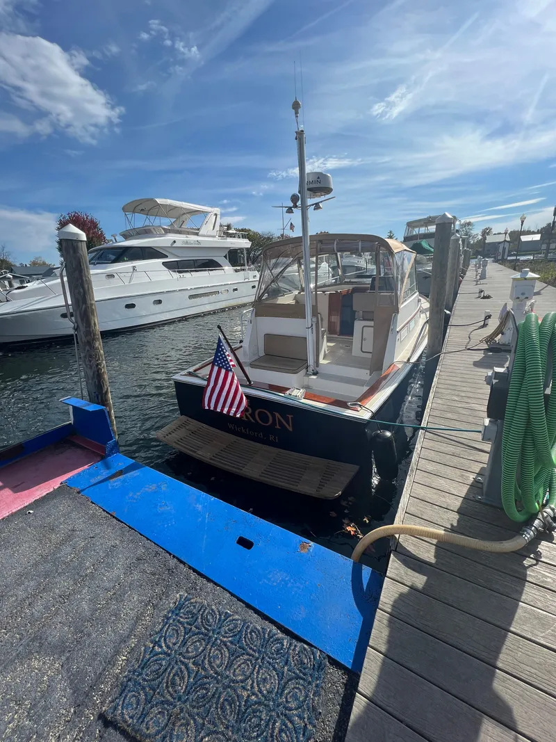 Slide: The Image of Bruckmann Bluestar 29.9 (2000) docked at a marina with an American flag. - 10