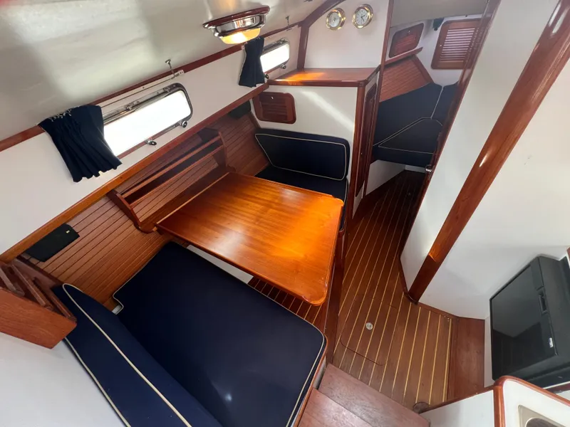 Slide: The Image of Interior of 2000 Bruckmann Bluestar 29.9 yacht with wooden table and seating. - 23