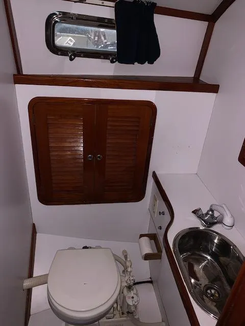 Slide: The Image of 2000 Bruckmann Bluestar 29.9 boat bathroom with toilet, sink, and wooden cabinets. - 34