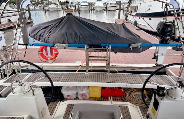 Slide: The Image of Beneteau Oceanis 48 (2019) yacht docked, featuring dual steering wheels and covered equipment. - 11