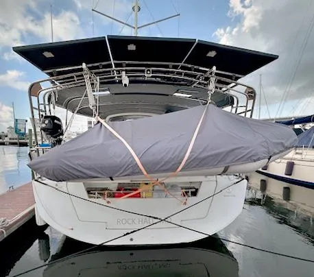 Slide: The Image of 2019 Beneteau Oceanis 48 yacht docked with covered dinghy on stern. - 2