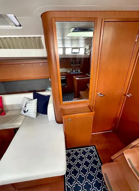 Slide: The Image of Interior of 2019 Beneteau Oceanis 48 yacht with wooden cabinetry and white seating. - 20