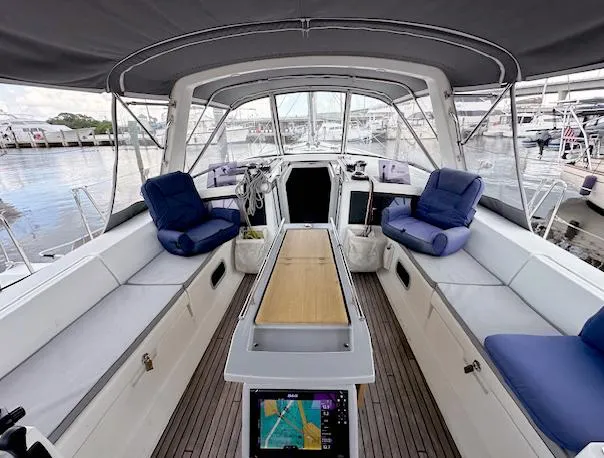 Slide: The Image of 2019 Beneteau Oceanis 48 yacht cockpit with cushioned seating and navigation equipment. - 3