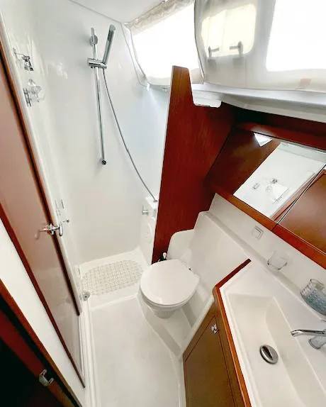 Slide: The Image of 2019 Beneteau Oceanis 48 yacht bathroom with shower, sink, and toilet. - 38
