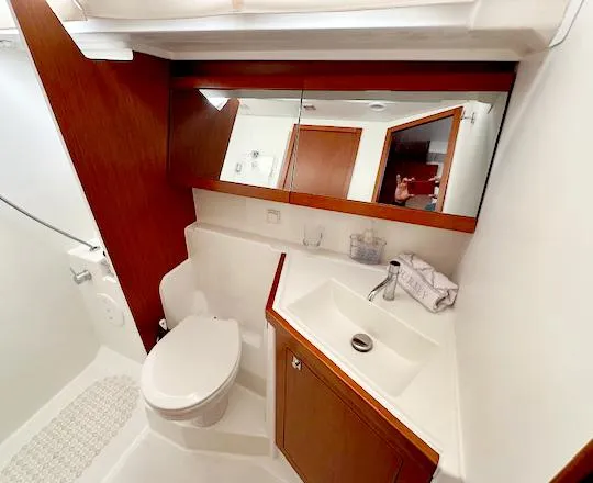 Slide: The Image of 2019 Beneteau Oceanis 48 yacht bathroom with modern fixtures and wooden cabinetry. - 39