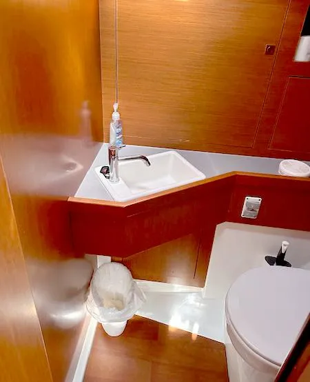 Slide: The Image of 2019 Beneteau Oceanis 48 bathroom with modern sink and wooden cabinetry. - 41