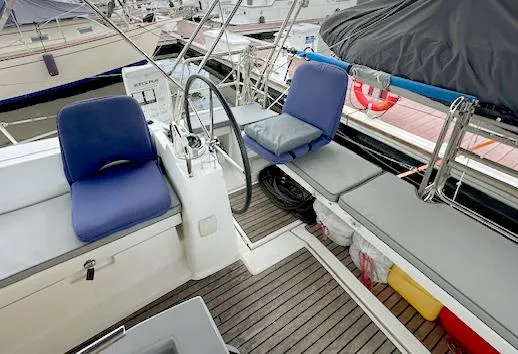 Slide: The Image of Cockpit of 2019 Beneteau Oceanis 48 sailboat with blue cushions and steering wheel. - 8