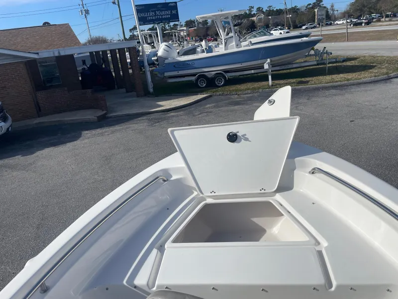 Slide: The Image of 2024 Key West 189 FS boat with open storage compartment at a marina. - 16