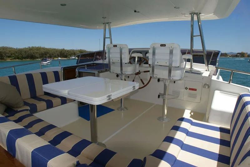 Slide: The Image of Flybridge of 2026 Selene 60 Classic Explorer yacht with striped seating and helm chairs. - 24