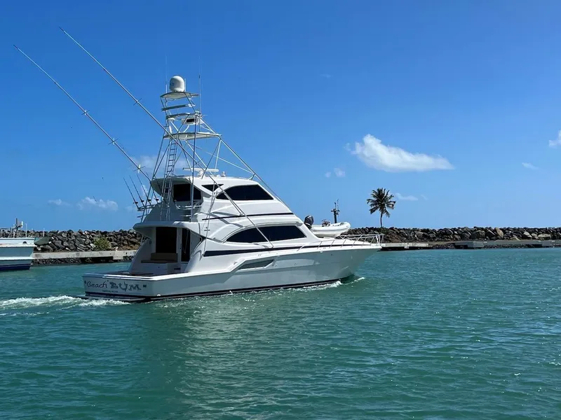 Slide: The Image of 2004 Bertram 670 yacht cruising in clear blue waters. - 12