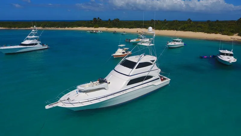 Slide: The Image of Luxury Bertram 670 yacht anchored in turquoise waters near a sandy beach, 2004 model. - 20