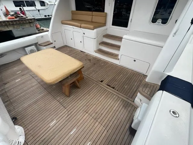 Slide: The Image of Spacious deck of a 2004 Bertram 670 yacht with wooden flooring and seating area. - 23