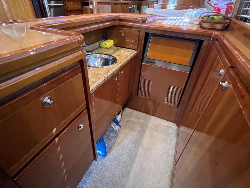 Slide: The Image of 2004 Bertram 670 yacht kitchen with wooden cabinetry and granite countertops. - 26