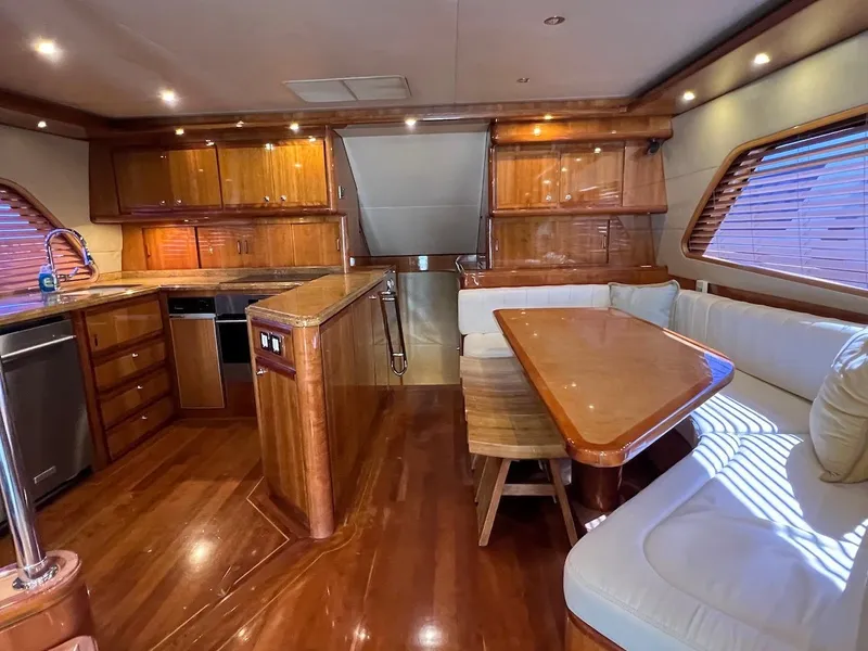 Slide: The Image of Luxurious interior of a 2004 Bertram 670 yacht with wooden cabinetry and dining area. - 28