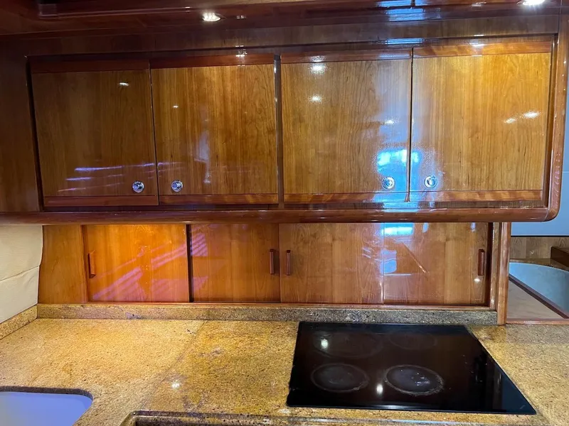Slide: The Image of 2004 Bertram 670 yacht kitchen with wooden cabinets and granite countertops - 33
