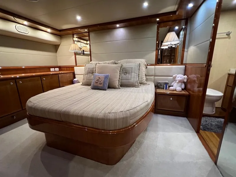 Slide: The Image of Luxurious bedroom in a 2004 Bertram 670 yacht with plush bedding and elegant wood finishes. - 35