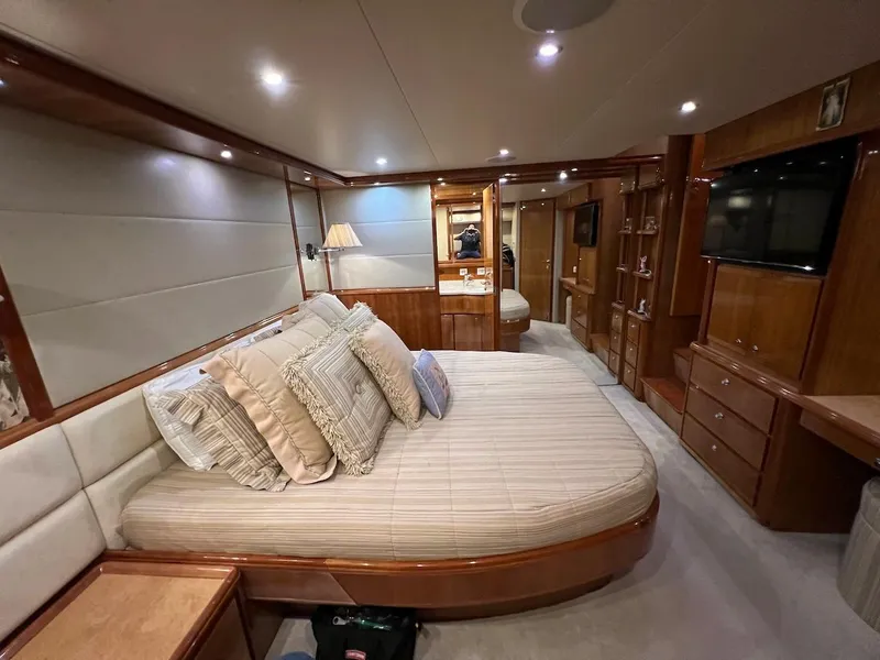 Slide: The Image of Luxurious bedroom interior of a 2004 Bertram 670 yacht with plush bedding and wooden furnishings. - 36