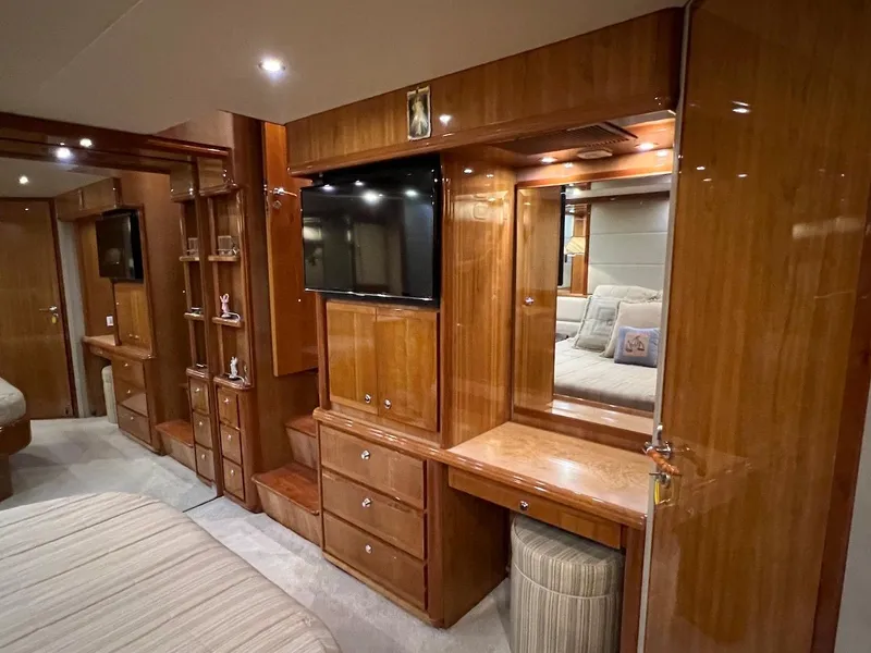Slide: The Image of Luxurious wooden interior of a 2004 Bertram 670 yacht bedroom with TV and vanity. - 37