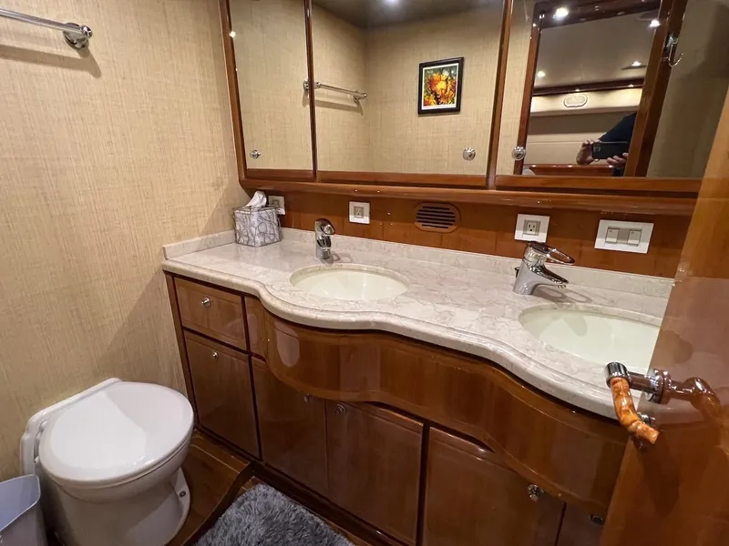 Slide: The Image of Luxurious bathroom in a 2004 Bertram 670 yacht with dual sinks and wooden cabinetry. - 38