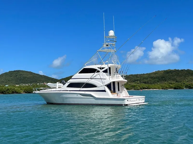 Slide: The Image of 2004 Bertram 670 yacht on clear blue water with scenic background. - 4