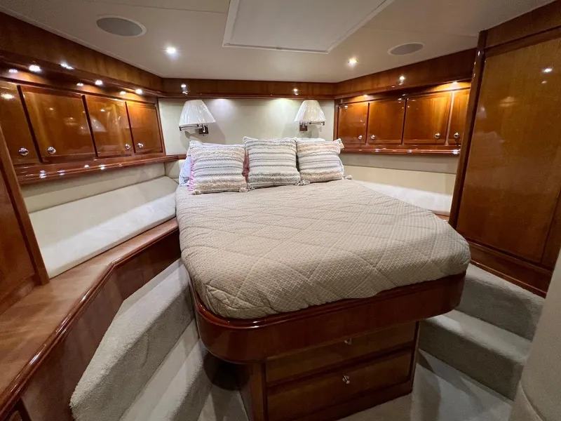 Slide: The Image of Luxurious bedroom interior of a 2004 Bertram 670 yacht with wooden cabinetry and cozy bedding. - 41