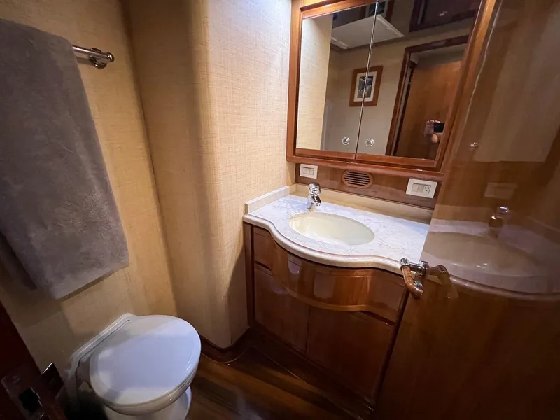 Slide: The Image of Bertram 670 2004 yacht bathroom with sink, mirror, and toilet. - 44