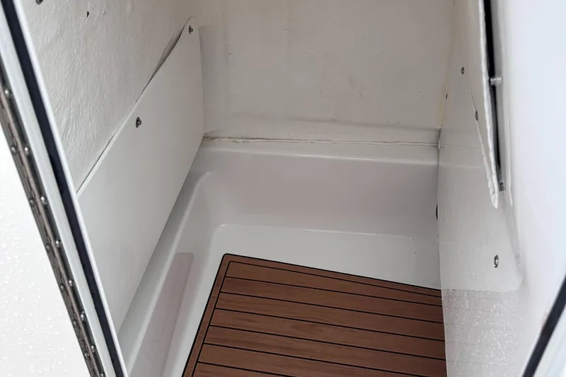 Slide: The Image of 2024 NauticStar 222L Offshore interior compartment with wood flooring. - 7