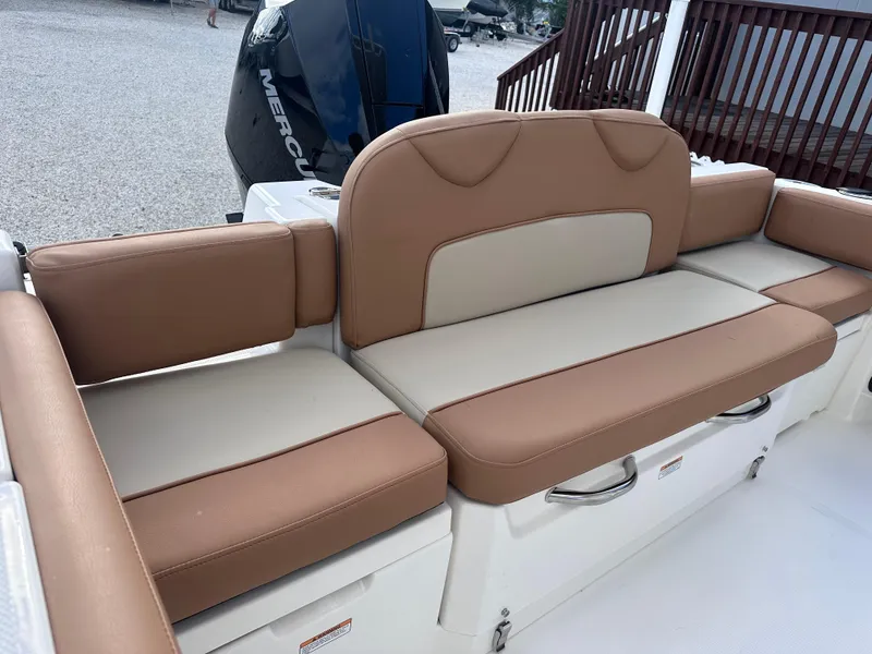 Slide: The Image of 2024 NauticStar 222L Offshore boat with tan and beige cushioned seating. - 8