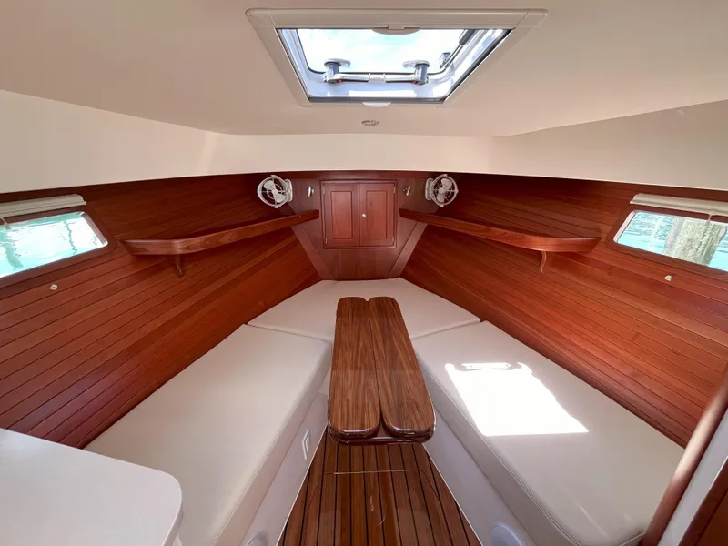 Slide: The Image of 2024 MJM 35 boat interior with wooden accents and cushioned seating. - 16