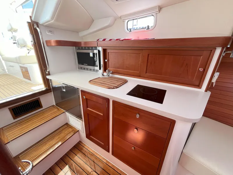 Slide: The Image of 2024 MJM 35 yacht interior kitchen with wooden cabinets and modern appliances. - 19