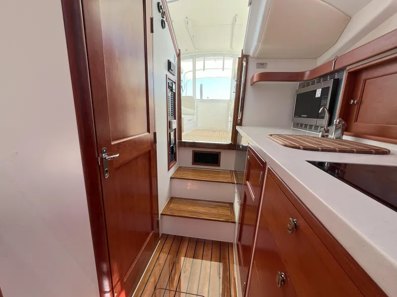Slide: The Image of 2024 MJM 35 yacht interior with wooden cabinetry and steps leading to deck. - 20