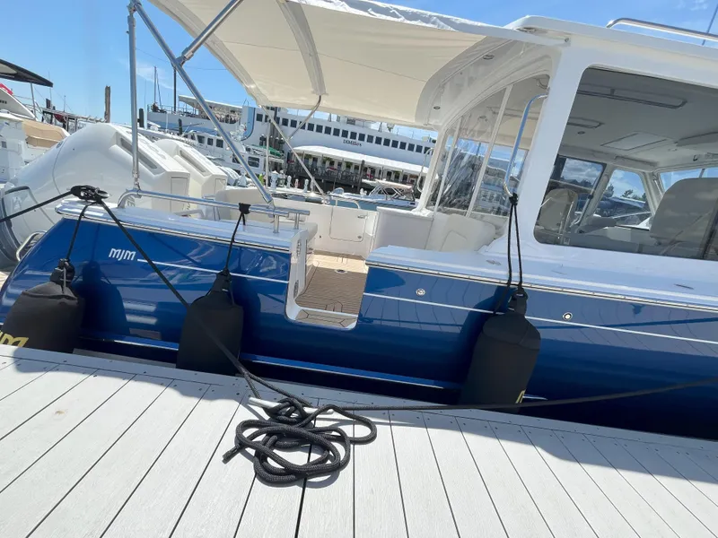 Slide: The Image of 2024 MJM 35 boat docked with blue hull and white canopy. - 5