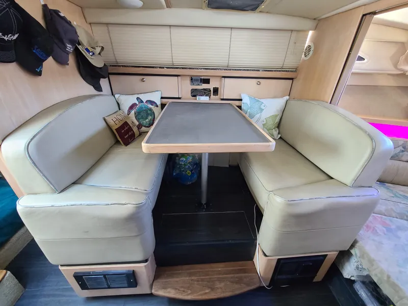 Slide: The Image of 1995 Bayliner Avanti interior dining area with cushioned seating and table. - 12