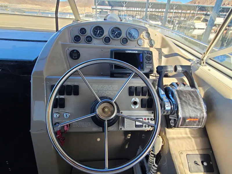 Slide: The Image of 1995 Bayliner Avanti boat helm with steering wheel and control panel. - 9