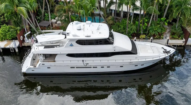 Slide: The Image of Monte Fino 82 yacht, 1999 model, docked near lush tropical surroundings. - 1