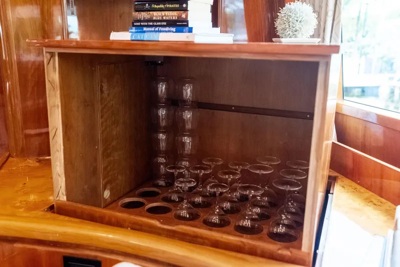Slide: The Image of Wooden cabinet with glassware and books on a 1999 Monte Fino 82 yacht. - 32