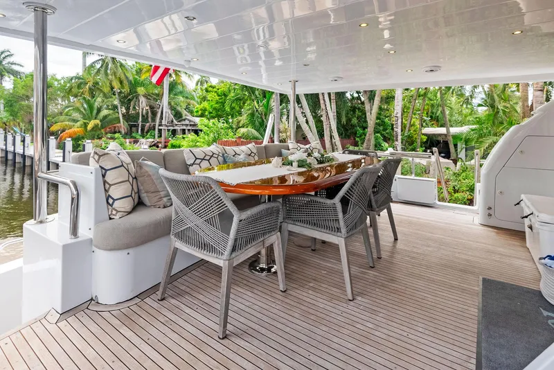 Slide: The Image of Luxurious outdoor dining area on 1999 Monte Fino 82 yacht, surrounded by lush greenery. - 5