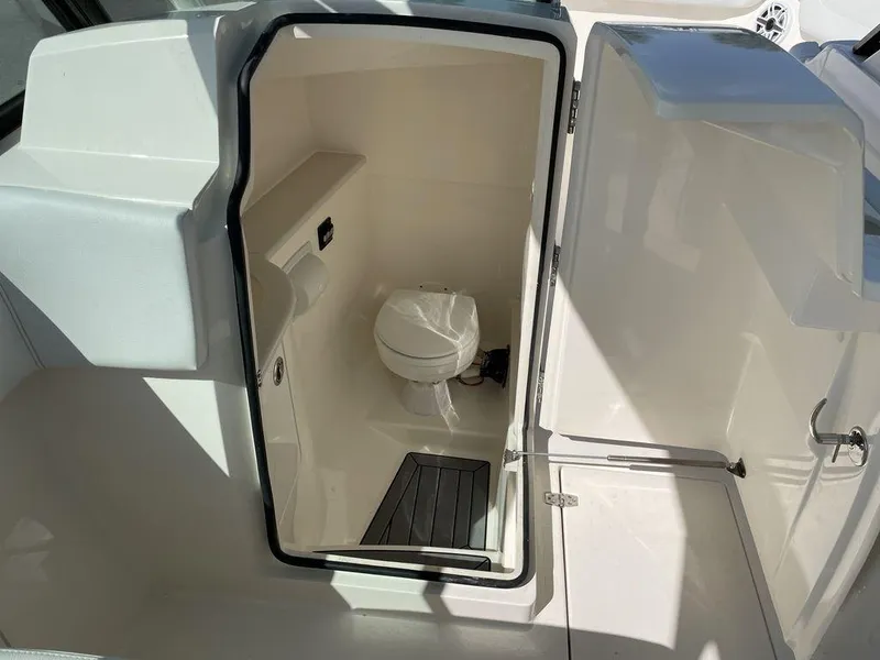Slide: The Image of 2022 Cobia 280 DC boat interior with a compact marine toilet. - 10