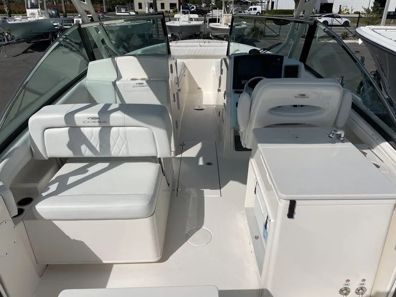 Slide: The Image of 2022 Cobia 280 DC boat interior with white seating and helm station. - 13