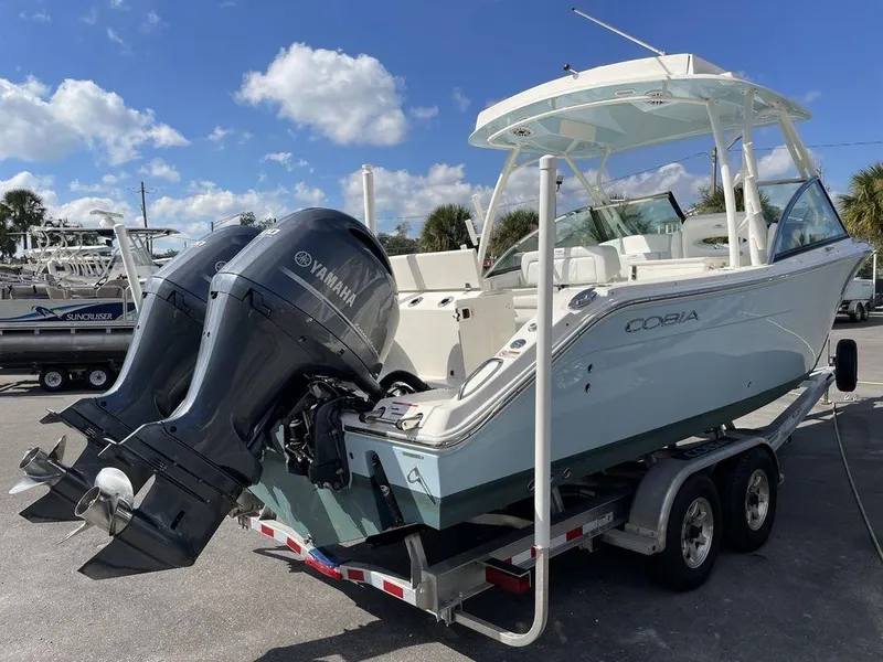 Slide: The Image of 2022 Cobia 280 DC boat with twin Yamaha engines on a trailer. - 17