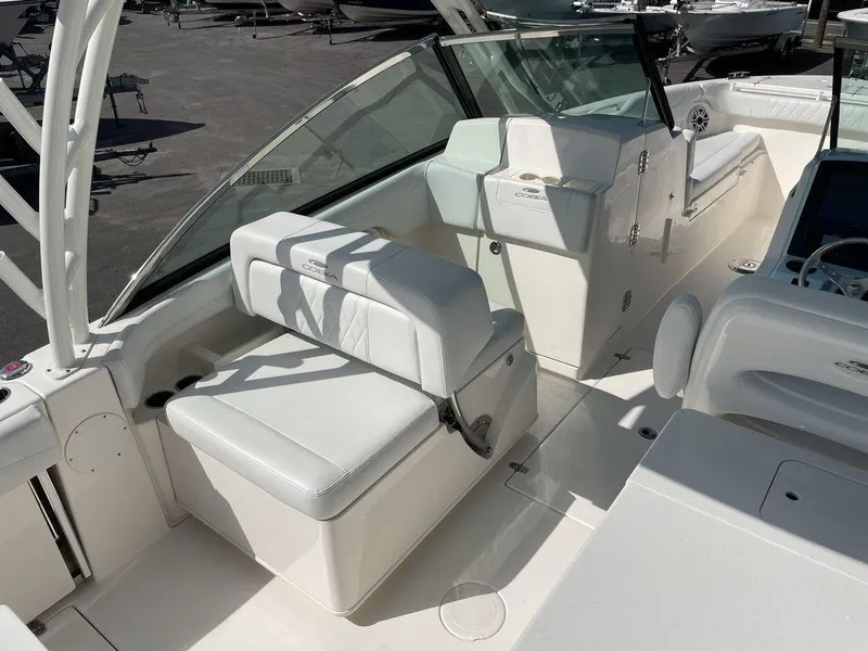 Slide: The Image of 2022 Cobia 280 DC boat interior with white seating and helm station. - 19