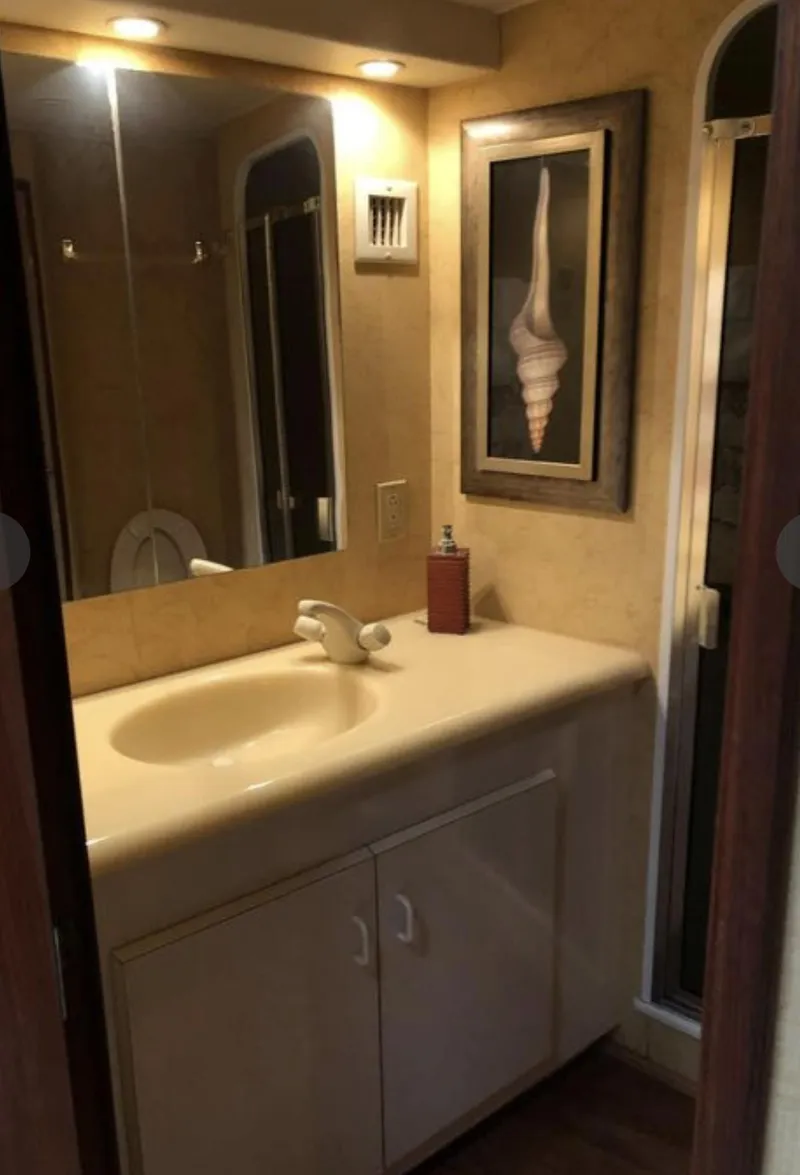 Slide: The Image of Bathroom interior of 1995 Viking 58 Convertible yacht with sink and seashell artwork. - 10