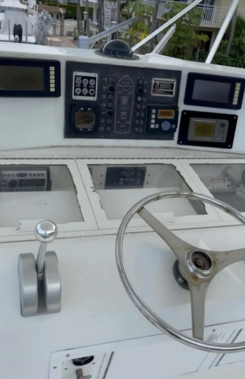 Slide: The Image of 1995 Viking 58 Convertible boat dashboard with steering wheel and control panel. - 4