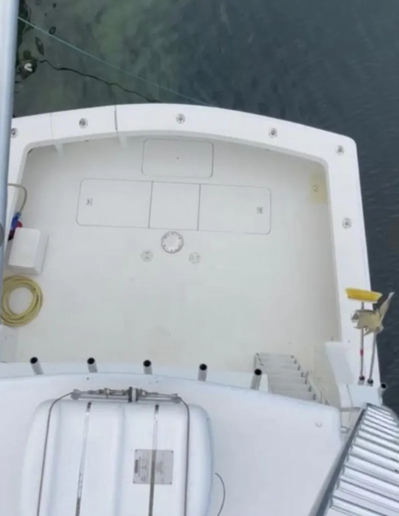 Slide: The Image of 1995 Viking 58 Convertible boat deck, aerial view, with clean white surface and fishing equipment. - 5